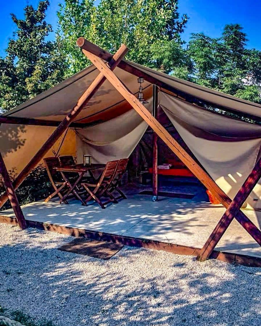 Lodge glamping con tavolo in veranda e alberi